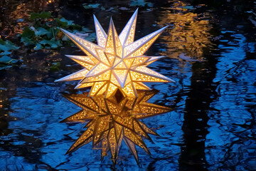 A nativity star reflected in a frozen pond at night, serene, celestial Christmas symbolism