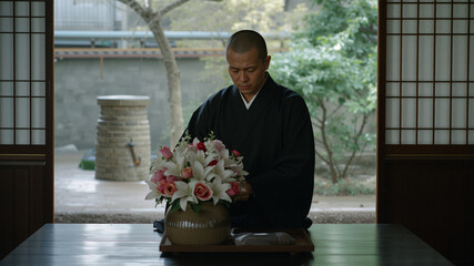 Japanese Monk Arranging Ikebana Flowers in Temple Garden