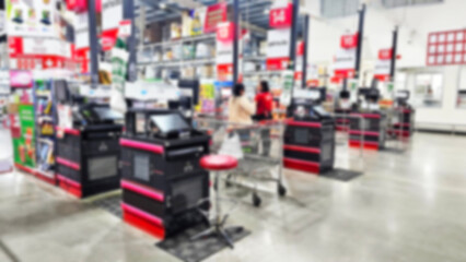Obraz premium Checkout Lines in Supermarket: A blurry interior shot showcasing several checkout lines in a bustling supermarket, conveying a sense of customer traffic.