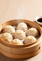 Fototapeta premium Chinese xiaolongbao soup dumplings steaming in bamboo basket