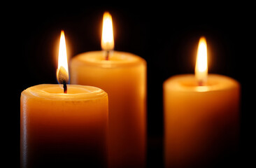 Warm candle flame glow trio black background peaceful mood soft light