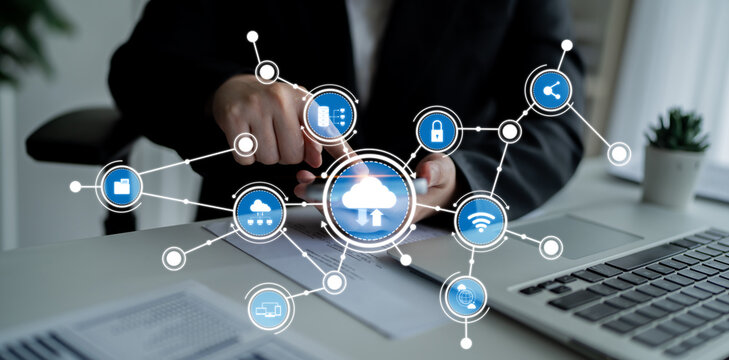 A business professional interacts with cloud technology icons on a smartphone and laptop, symbolizing connectivity and digital innovation in a modern workspace setting. Crux