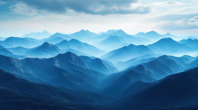 Breathtaking blue mountain range vista with soft atmospheric haze and dramatic sky, conveying peace and vastness for your next project.