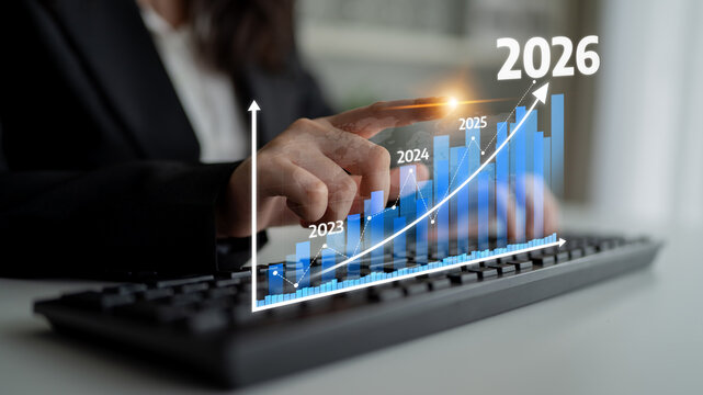 A businessperson analyzes growth chart data while typing on a keyboard, representing future predictions and trends in a modern office setting focused on financial success. Tessel - Powered by Adobe