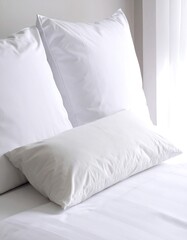 Three white pillows on a bed with crisp, smooth, white bedding