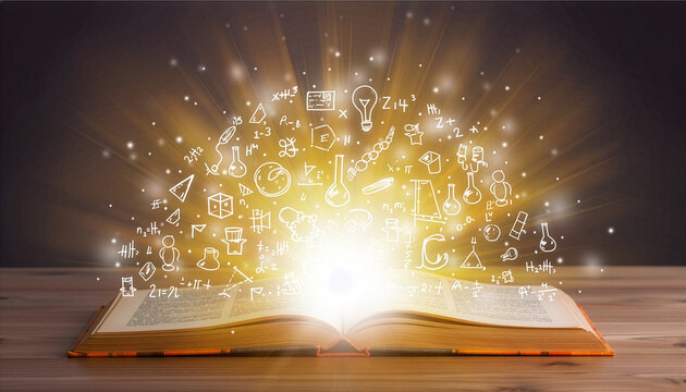 Conceptual image of an open book unleashing a magical explosion of knowledge, ideas, and scientific discovery symbols on a wooden table