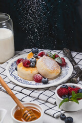 Cheesecakes with powdered sugar and berries on a plate