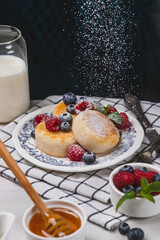 Cheesecakes with powdered sugar and berries on a plate