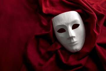 White mask red fabric theater mystery drama