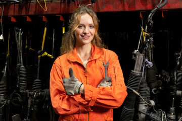 Female technician worker standing and smile to the camera in garage scrap yard warehouse.
