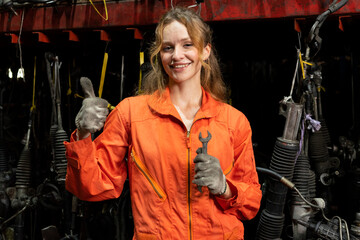 Female technician worker standing and smile to the camera in garage scrap yard warehouse.