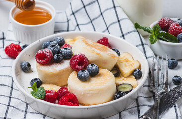 Cheesecakes with powdered sugar and berries on a plate
