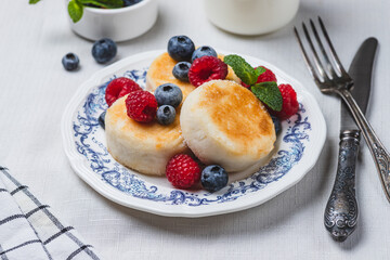 Cheesecakes with powdered sugar and berries on a plate