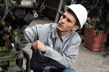 Technician worker working and checking in garage scrap yard car workshop warehouse.