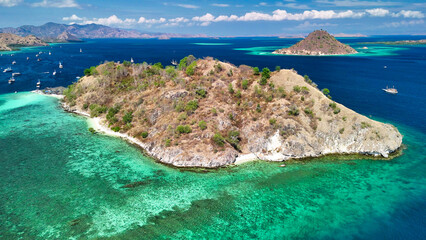 Aerial view of Pulau Kelor in Komodo National Park with snorkelers swimming near small sharks