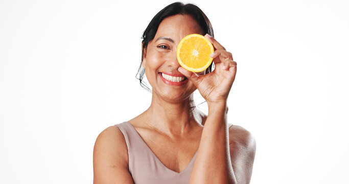 Portrait, skincare and mature woman with orange, mockup space or facial treatment with antioxidants. White background, natural cosmetics and fruit with vitamin c, anti aging and self care in studio