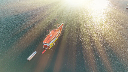Scenic aerial landscape showing a small boat navigating tropical paradise waters from above