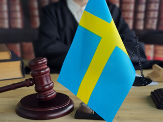A courtroom with a gavel and the Swedish national flag on display during a trial. The Swedish...