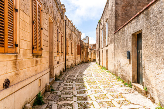 old narrow italian street in traditional mediterranean style with yellow stone walls and beautiful windows. Amazing antuque buildings on a old inalian street. - Powered by Adobe