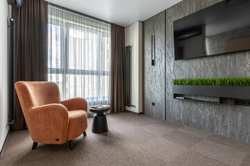 Modern Living Room Corner with Orange Armchair and TV Wall