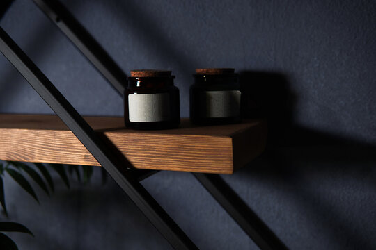 Modern wall shelf with geometric design. Decorative wooden and metal shelf on a dark wall. Designer diamond-shaped wall shelf in loft style