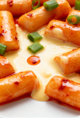 Creamy Korean tteokbokki fusion with cheese sauce and scallions