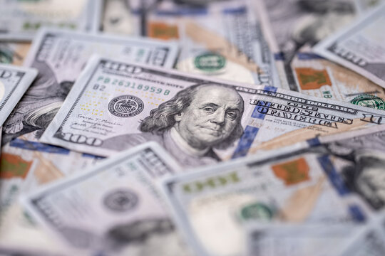 Money background with 100-dollar bills. Texture of US currency. 100 USD banknotes in focus. American hundred-dollar notes spread on a table. Pattern of US dollars for finance concept.