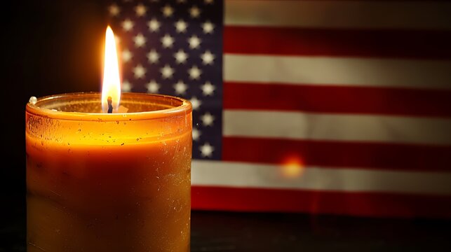 A glowing candle illuminates in front of a blurred american flag backdrop