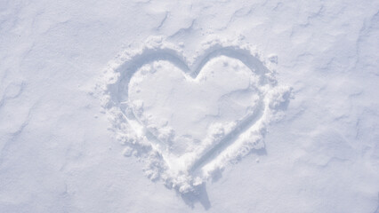 Snow heart on a white winter background. Frosty heart shape in snowy field. Romantic snow heart drawing outdoors. Winter love symbol on frozen surface. Snowflake heart detail. Snow love.