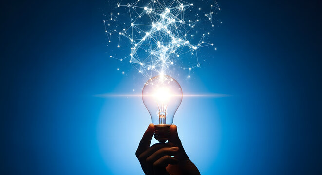 Hand holding a glowing light bulb with a bright blue energy burst above