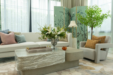 Interior of a luxurious sitting room with bay window sofas and coffee table. White and green tone of vast luxury living room.

