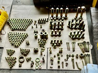 Various sizes of bolts, nuts, and washers neatly arranged on cardboard, showing industrial hardware...