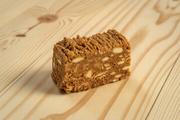 A close-up photograph of a golden-brown piece of halva