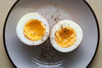 A photo of a plate with two halves of a boiled egg