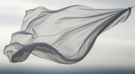Abstract image of a sheer gray fabric floating in the air against the sky