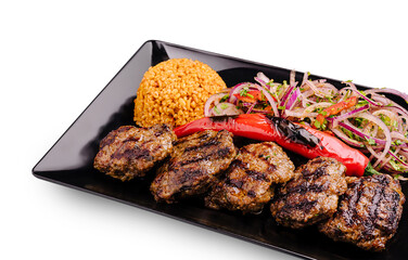 Grilled meat platter with bulgur and fresh vegetables served in a restaurant