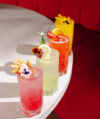 Colorful cocktails with flowers on a table in a trendy bar setting
