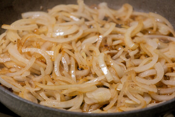 caramelizing onion slices in a pan