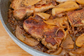 delicious pork chop with onion and apples in pan fall meal