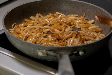 caramelizing onion slices in a pan