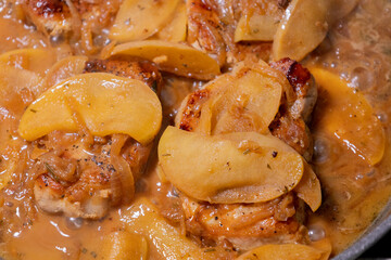 cooking pork chop with apples in a pan