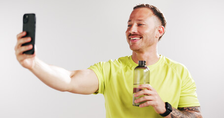 Selfie, water and fitness with man in studio for social media gym membership promotion and memory. Profile picture, personal trainer post and photography with person and bottle on white background