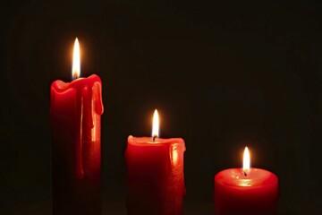 three red candles with distinct flame sizes