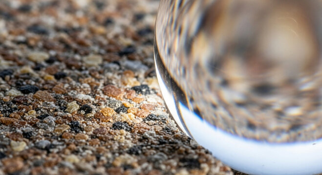 Closeup of a crystal ball on a textured surface with blurred reflection - Powered by Adobe