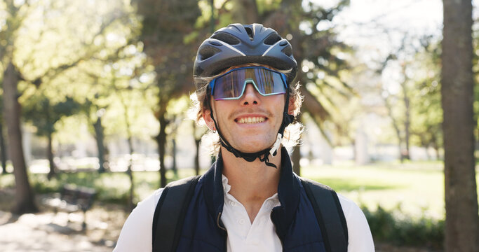 Man, courier and portrait with helmet at park, smile and confident with pride, commute or service. Person, safety and backpack for delivery with eco friendly transport, happy or sunglasses in Germany