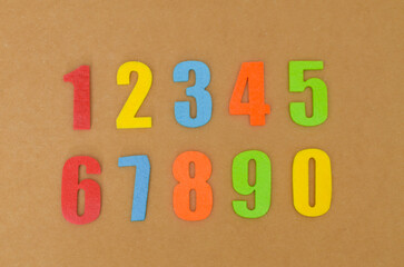 Bright Numbers for Kids' Crafts: Colorful, solid-color felt cutouts of numbers 0-10, arranged on cardboard for a fun, tactile learning or DIY project.