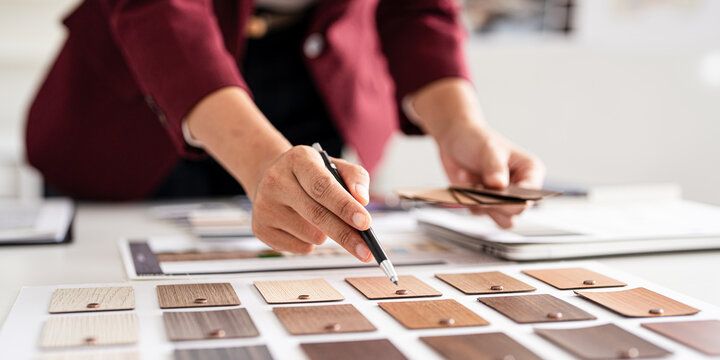 close up hand of Professional interior designer working in the office, asian female architect working on business of Real estateproject , sketching on a house plan choosing swatches and material.
