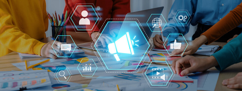 A creative team collaborates on marketing strategies, surrounded by colorful designs and digital graphics representing communication and engagement concepts, showcasing teamwork and innovation. Trope