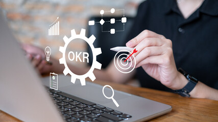 Businessman working on OKR objective key result quality planning strategy for business success goal...