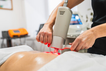 Technician using a physioactive massage system with rotating heads on a client's back, providing deep tissue treatment